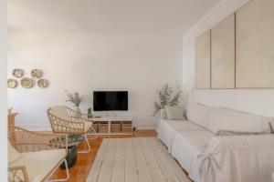 Una sala de estar con un sofá blanco y sillas. en Bento Caraça Terrace, en Alcácer do Sal