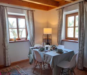comedor con mesa, sillas y ventanas en Blumenstube, en Sant’Orsola