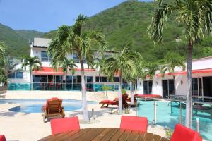 a resort with palm trees and a swimming pool at Hotel Med Taganga in Taganga