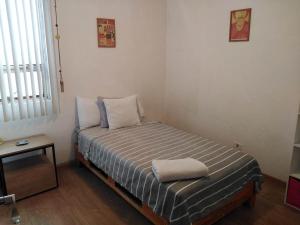 a small bed in a room with a table at Depa Cholulita in Cholula