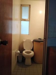 a small bathroom with a toilet and a window at Depa Cholulita in Cholula