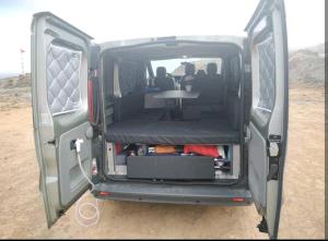 a van with its doors open with a table in the back at Autocaravana Camper in Las Palmas de Gran Canaria