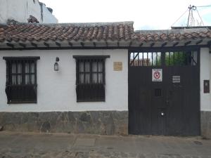 een wit huis met een zwarte deur en ramen bij Casa Gloria en Villa de Leyva in Villa de Leyva