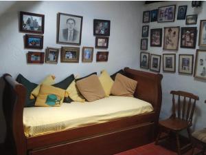 Bett in einem Zimmer mit Bildern an der Wand in der Unterkunft Casa Gloria en Villa de Leyva in Villa de Leyva