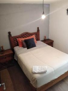 1 dormitorio con 1 cama blanca grande con almohadas en Depa Cholulita, en Cholula