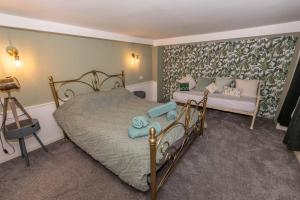 a bedroom with a bed and a couch at The Tempest, sea views, coastal & rural walks. in Ilfracombe
