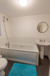 a bathroom with a tub and a sink and a toilet at The Tempest, sea views, coastal & rural walks. in Ilfracombe
