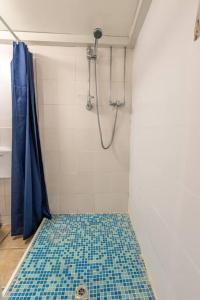 a bathroom with a shower with a blue tile floor at The Tempest, sea views, coastal & rural walks. in Ilfracombe