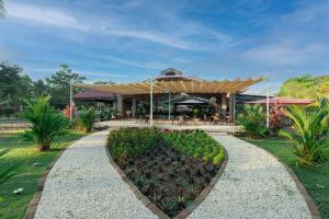 ein Resortgebäude mit einer Hecke davor in der Unterkunft Hotel Costa Pacifica in Esterillos