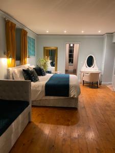 a bedroom with a large bed and a desk at Clone Country House in Aughrim