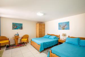 een hotelkamer met 2 bedden en een stoel bij Serene by the Sea in Savaneta