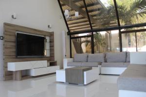 a living room with white furniture and a flat screen tv at Hotel Med Taganga in Taganga