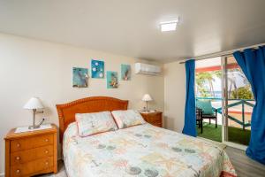 a bedroom with a bed with blue curtains and a window at Serene by the Sea in Savaneta