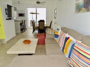 ein Wohnzimmer mit einem Sofa und einem Tisch in der Unterkunft Casa Los Amores in Bucerías