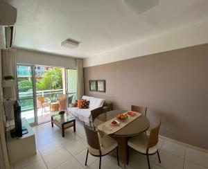 a living room with a table and a couch at Apto. Palm Beach, 300M Beach Park in Aquiraz