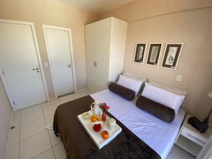 Un dormitorio con una cama con una bandeja de fruta. en Apartamento Palm Beach - 300m Beach Park, en Aquiraz