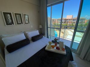 Un dormitorio con una cama con una bandeja de comida. en Apartamento Palm Beach - 300m Beach Park, en Aquiraz
