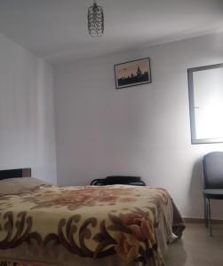 - une chambre avec un lit, une chaise et une fenêtre dans l'établissement Havre de Paix chez Lamine, à Harhoura