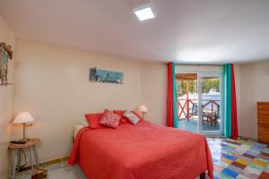 um quarto com uma cama com uma colcha vermelha em Serene by the Sea em Savaneta