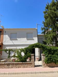 a white building with a fence in front of it at Paz Jardín-Madrigueras in Madrigueras