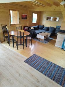sala de estar con sofá, mesa y sillas en Domek całoroczny, en Zastań
