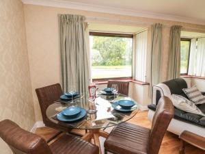 een woonkamer met een tafel en stoelen en een bank bij Red Tree Cottage in York