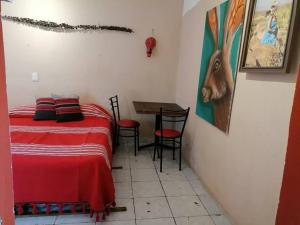 モンテレイにあるRojoMecate estudio artistico en Monterrey Ponienteのベッドルーム1室(ベッド1台、テーブル、椅子付)