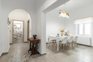 una sala da pranzo bianca con tavolo e sedie bianchi di Villa Maro - Luxury Apartment a Naxos Chora