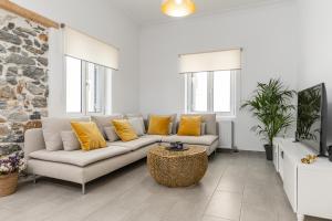 a living room with a white couch and yellow pillows at Villa Maro - Luxury Apartment in Naxos Chora