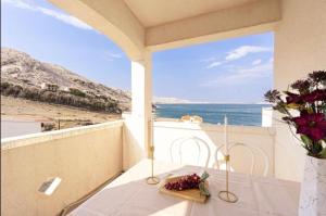 a balcony with a table and a view of the ocean at Apartments with parking space Metajna, Pag - 208 in Metajna