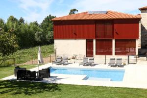 a building with a swimming pool and a red building at Quinta de Chousas - Braga - Agroturismo in Braga