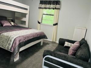 1 dormitorio con 1 cama y 1 sofá en Resort Home on .5 Wooded Acres Sleeps up to 12. Firepit for Smores! en Hot Springs