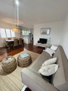 uma sala de estar com um sofá e uma mesa em Beach House @ Moffat em Caloundra