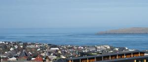 a view of a city with the ocean in the background at Stunning Sea View / 1 bedroom apartment / Tórshavn in Tórshavn
