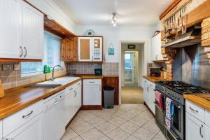 a kitchen with white cabinets and a stove at Sea Grove in Ventnor