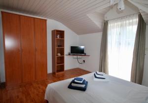 1 dormitorio con 1 cama, armario y TV en Apartment Bol 2904a, en Bol