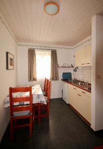 a kitchen with a table and chairs in a room at Apartments by the sea Bol, Brac - 2904 in Bol