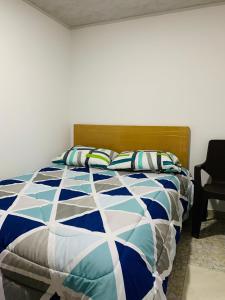 a bedroom with a bed with a blue and white comforter at Bogotá Kings 301 in Bogotá