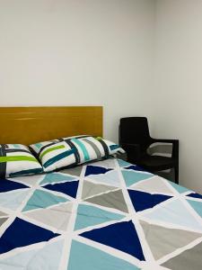 a bed with a blue and white quilt and a chair at Bogotá Kings 301 in Bogotá