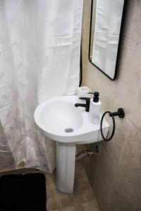 a white sink in a bathroom with a mirror at Exclusive on Rio Negro in Montevideo