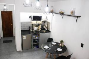 a small kitchen with a black table and a table and chairs at Apart Hotel Montevideo in Montevideo