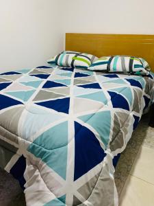 Una cama azul y blanca con almohadas. en Bogotá Kings 301, en Bogotá