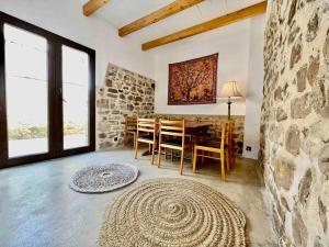 uma sala de jantar com uma mesa e uma parede de pedra em La Casa de Ubeda em Úbeda