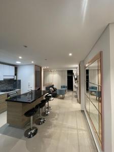 a kitchen and living room with a black counter and stools at Edificio M-30 in Ibagué