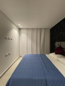 a bedroom with a large bed with a blue blanket at Edificio M-30 in Ibagué