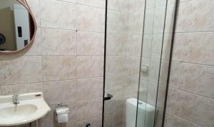 a bathroom with a toilet and a sink and a mirror at Quarto Divas na Sakura House in Indaiatuba +3 photos