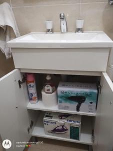 un lavabo blanco debajo de un fregadero blanco en Excelente departamento en Neuquen en Neuquén