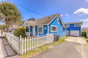 a blue house with a white picket fence at Pearl off the Prom in Seaside