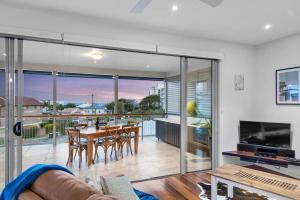 スカボローにあるPenthouse - Scarborough beach break holidaysのテーブルと椅子とテレビのあるリビングルーム