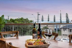 a table with two bottles of wine and a plate of food at Penthouse - Scarborough beach break holidays in Scarborough +7 photos